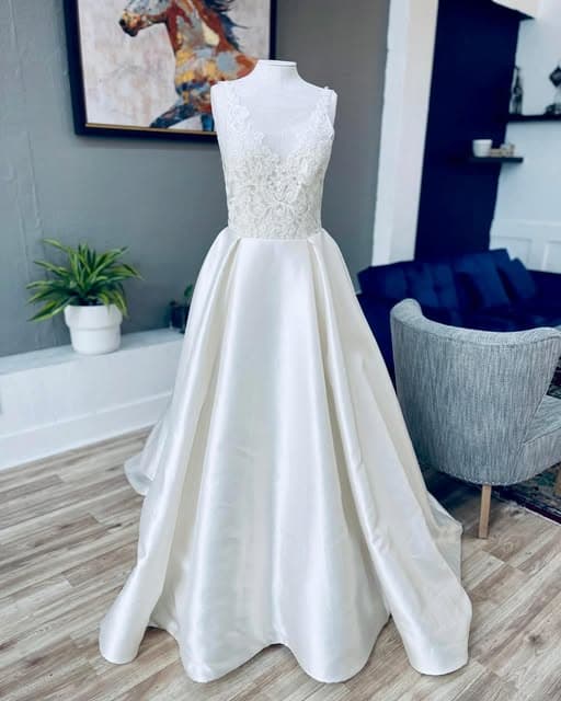 Ivory bridal gown with a full skirt fitted on a dress form