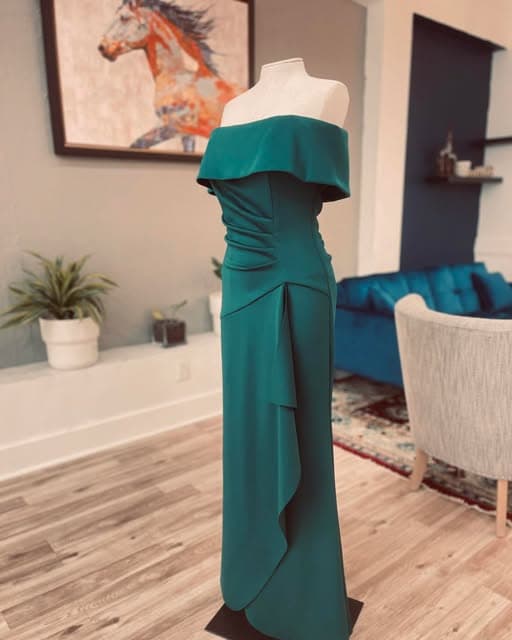 Emerald green off-the-shoulder gown fitted on a dress form